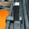 Photograph of the 4040 snap on clip installed on an extrusion. This print has a long tab opposite the hooks to allow the clip to be pried out of the extrusion.