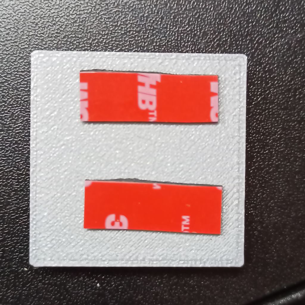 The system case with two strips of 3M VTB tape on the back