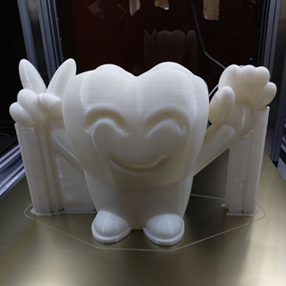 A "happy tooth" printed for a dentist's office (supports visible in background.)